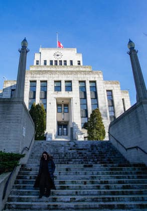 (260212) -- VANCOUVER, Feb. 12, 2026 -- A woman walks down the staircase as the Canadian national flag flies at half-mast over Vancouver City Hall in Vancouver, British Columbia, Canada, Feb. 11, 2026. Canadian Prime Minister Mark Carney on Wednesday ordered all flags on Parliament Hill and federal buildings across Canada to be flown at half-mast for seven days as the country mourns the victims of a mass shooting in Tumbler Ridge, British Columbia province. The shooting claimed 10 lives, including the shooter, making it one of the deadliest mass shootings in Canadian history. (Photo by Xinhua) CANADA-VANCOUVER-MASS SHOOTING-FLAGS-HALF-MAST LiangxSen 