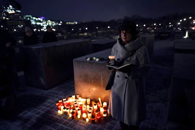 Holocaust Memorial - Auschwitz Gedenken Deu, Deutschland, Germany, Berlin, 26.01.2026 Besucher mit Kerzen bei den Stelen vom Holocaust-Mahnmal bei der Zeremonie zum Gedenken an die Opfer des Holocaust am Denkmal und Mahnmal für die ermordeten Juden Europas zum 81. Jahrestag der Befreiung des Vernichtungslagers Auschwitz am Holocaust-Gedenktag am 27. Januar 2026 in Berlin Deutschland . In Gedenken der Befreiung von Auschwitz veranstaltet die juedische Gemeinde und antifaschistische Initiativen unter dem Motto Kein Vergessen Kein Vergeben zur Erinnerung an die ermordeten Juden Europas im Dritten Reich en: Visitor with candles at a stelae of the Holocaust Memorial during the ceremony commemorating the victims of the Holocaust at the Memorial
