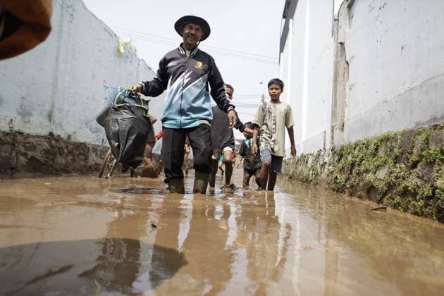February 12, 2026, Bandung, West Java, Indonesia: A number of teachers and students walk through mud left behind after flooding caused by a broken embankment in Majalaya, Bandung Regency, West Java, Indonesia. The Bandung Regency Regional Disaster Management Agency (BPBD) recorded that five houses were severely damaged and seven others sustained moderate damage, with a total of around 310 households, or approximately 660 people, affected by the incident. Bandung Indonesia  - ZUMAa305 20260212_zip_a305_098 Copyright: xArdixSeptianx