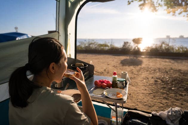 Woman enjoying breakfast while camping in Portugal A woman enjoys a peaceful breakfast in her tent while camping by a scenic seaside in Portugal. The scene captures the essence of outdoor adventure and tranquility. Model Released JuanAlbertoRuiz_ID32581_1110054_035 Copyright: xJuanxAlbertoxRuizx RECORD DATE NOT STATED