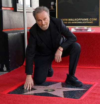Italian actor Franco Nero kneels on his star during an unveiling ceremony honoring him with the 2,835th star on the Hollywood Walk of Fame in Los Angeles on Thursday, February 12, 2026.  LAP2026021202 JIMxRUYMEN