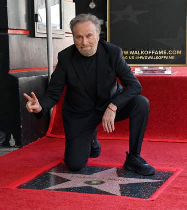 Italian actor Franco Nero kneels on his star during an unveiling ceremony honoring him with the 2,835th star on the Hollywood Walk of Fame in Los Angeles on Thursday, February 12, 2026.  LAP2026021203 JIMxRUYMEN