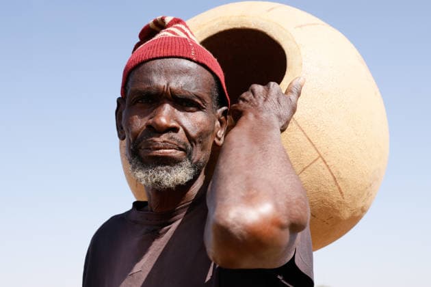 News Bilder des Tages Argungu International Fishing and Cultural Festival in Nigeria KEBBI, NIGERIA - FEBRUARY 14: A man poses for a photo as people prepare for the fishing competition in the Matan Fada River during the Argungu International Fishing and Cultural Festival, which continues in Kebbi State, Nigeria, on February 14, 2026. As part of the festival, following the organisers signal for the fishing competition, hundreds of participants jumped into the river and attempted to catch the largest fish using traditional methods. The festival aims to promote the region’s agricultural potential and contribute to the local economy. Emmanuel Osodi Anadolu Kebbi Nigeria. Editorial use only. Please get in touch for any other usage.  Copyright: x2026xAnadoluxEmmanuelxOsodix