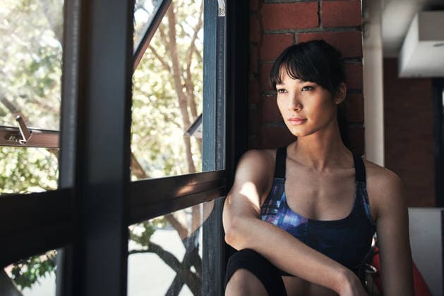 Thinking, woman and relax with window at gym with vision, planning and ideas for exercise break. Thoughts, female person and resting with reflection, outdoor view and daydreaming for fitness recovery. model released property released Copyright: xlicencexrestrictionsxapplyx