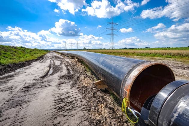 Bau einer Gaspipeline, Nahaufnahme von einem Teilstück der zusammengeschweißten Gasleitung. Bau einer Gas - Pipeline durch Norddeutschland zur sicheren Versorgung Deutschlands mit Erd- und LNG - Gas. Schweres Gerät ist nötig, um die riesigen Rohre, die vor dem Versenken in dem vorher ausgebagerten Graben miteinander verschweißt werden, gleichmäßig in den Schacht abzusenken. Symbolfoto Region Weser-Ems Niedersachsen Deutschland