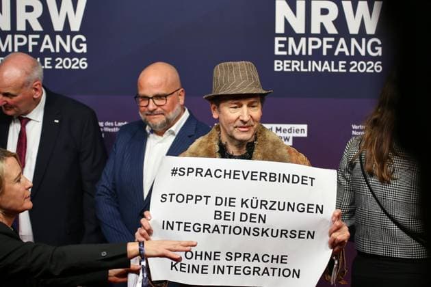 Berlin, Deutschland, 15.02.2026: NRW-Landesvertretung: Berlinale-Party der Filmstiftung: Schauspieler Piet Fuchs protestiert mit einem Schild und dem Text: Spracheverbindet - Stoppt die Kürzungen bei den Integrationskursen - Ohne Sprache keine Integration Copyright: xdtsxNachrichtenagenturx dts_106337