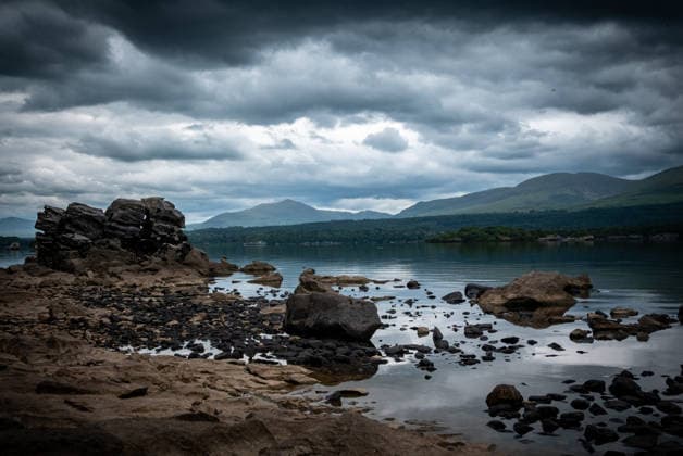 Ufer Lough Leane im Killarney National Park Irland Stimmungsvolle Aufnahme des felsigen Ufers am Lough Leane, dem größten See im Killarney National Park, Irland. Dunkle, dramatische Wolken hängen über den majestätischen Bergen im Hintergrund, die sich im ruhigen Seewasser spiegeln. Eine wilde, unberührte Naturkulisse in der Region Kerry. (License=RF) Copyright: xZoonar.com ThomasxErnstx 24645565