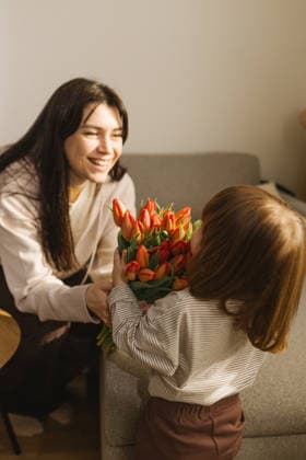 Toddler daughter giving a bouquet of orange tulips Varna, Varna, Bulgaria CR_PUZV260211-1954038-01 ,model released, Symbolfoto