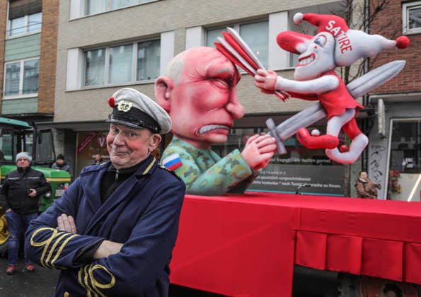 Mottowagen des Duesseldorfer Bildhauers Jacques Tilly am Montag (16.02.2026) auf dem Duesseldorfer Rosenmontagszug (Foto: Tilly vor dem Motivwagen - der russische Praesident Wladimir Putin spiesst den Hoppeditz mit einem Schwert auf. Die Duesseldorfer Karnevalsfigur wiederum schlaegt dem in Militaeruniform gekleideten Putin mit einer Narrenpritsche auf den Kopf). In Moskau laeuft aktuell ein Prozess gegen den Wagenbauer Tilly wegen Verunglimpfung der russischen Staatsorgane. Tilly nimmt nicht an dem Verfahren in Russland teil. (Siehe epd-Meldung vom 16.02.2026) EDITORIAL USE ONLY *** Theme float by Duesseldorf sculptor Jacques Tilly on Monday 16 02 2026 at the Duesseldorf Rose Monday parade Photo Tilly in front of the theme float Russian Pr Copyright: epd-bild Hans-JuergenxBauer epd-Rosenmontagszug_Duesseldorf1-kopieren