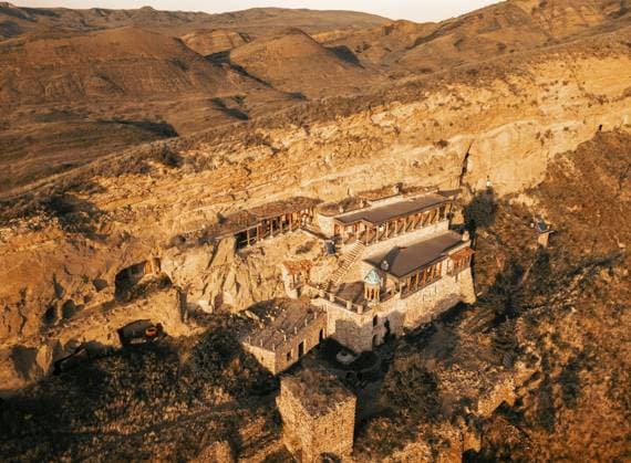 Luftaufnahme Der in Klippen gehauene Klosterkomplex Natlismtsemeli, mittelalterliche georgisch orthodoxe Architektur in den abgelegenen Hügeln von Kacheti. Teil des Klosterkomplexes von David Gareja. Aserbaidschan, Grenzzone Georgien Aerial view Natlismtsemeli Monastery complex carved into cliffs, medieval Georgian Orthodox architecture in remote Kakheti hills. Part of David Gareja monastic complex. Azerbaijan Georgia border zone Copyright: imageBROKER EvaldasxMikoliunas ibxemi16638955.jpg