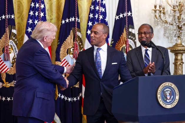 President Donald Trump shakes hands with U.S. Secretary of Housing and Urban Development Eric Turner as Former Housing and Urban Development Secretary Dr. Ben Carson (R) looks on during a reception for Black History Month in the East Room of the White House in Washington, DC on Wednesday, February 18, 2026. The event comes less than two weeks after President Trump s Truth Social account shared a racist video of former President Barack Obama and former First Lady Michelle Obama.  WASP20260218111 JIMxLOxSCALZO