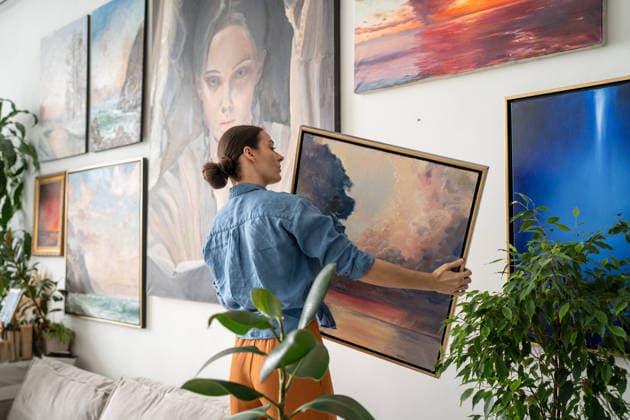 Eine konzentrierte, geschickte Künstlerin hängt Gemälde an eine Wand, die mit ihren eigenen Meisterwerken gefüllt ist. Eine konzentrierte, geschickte Künstlerin hängt Gemälde an eine Wand, die mit ihren eigenen Meisterwerken gefüllt ist. (License=RF) ,model released, Symbolfoto Copyright: xZoonar.com DmitriixMarchenkox 24685830 ,model released, Symbolfoto ,property released