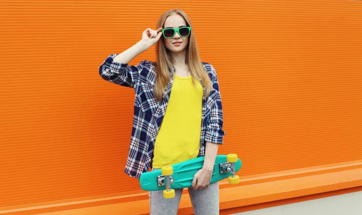 Stilvolle junge Frau mit Skateboard, modernes Teenager-Mädchen posiert auf der Stadtstraße Stylish young woman standing with skateboard in colorful clothes, cool modern teenage girl posing on orange background (License=RF) ,model released, Symbolfoto Copyright: xZoonar.com VeronikaxKornevax 24690131 ,model released, Symbolfoto ,property released