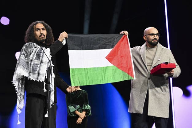 76th Berlin International Film Festival BERLIN, GERMANY - FEBRUARY 21: Director Abdallah Alkhatib (L) takes to the stage carrying the Palestinian flag after winning the Best Feature Film Award with his film Chronicles From the Siege at the 76th Berlin International Film Festival (Berlinale) in Berlin, Germany, on February 21, 2026. Halil Sagirkaya Anadolu Berlin Germany. Editorial use only. Please get in touch for any other usage.  Copyright: x2026xAnadoluxHalilxSagirkayax