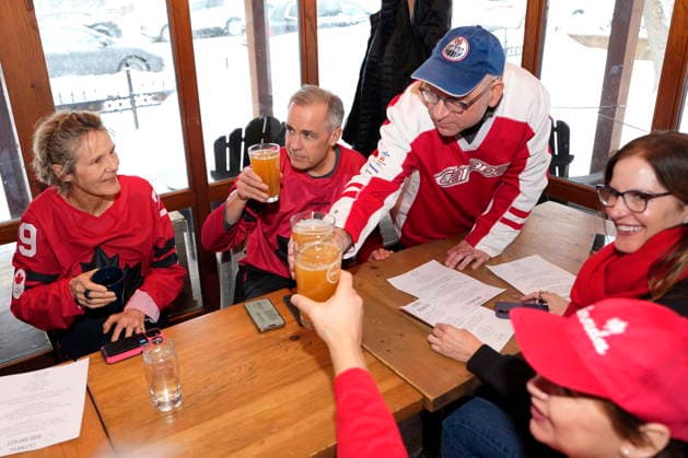 February 22, 2026, Chelsea, Pq, CAN: Prime Minister Mark Carney, centre, raises his glass as he and his wife Diana Fox Carney join family and friends to watch the gold medal men s ice hockey game between Canada and the United States at the 2026 Milan Cortina Winter Olympics, at a pub in Chelsea, Que., on Sunday, Feb. 22, 2026. Chelsea CAN  - ZUMAc35_ 20260222_zaf_c35_047 Copyright: xJustinxTangx
