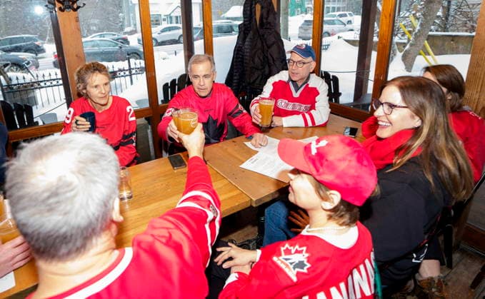 February 22, 2026, Chelsea, Pq, CAN: Prime Minister Mark Carney clinks glasses with friends as they watch the gold medal men s ice hockey game between Canada and the United States at the 2026 Milan Cortina Winter Olympics, at a pub in Chelsea, Que., on Sunday, Feb. 22, 2026. Chelsea CAN  - ZUMAc35_ 20260222_zaf_c35_048 Copyright: xJustinxTangx