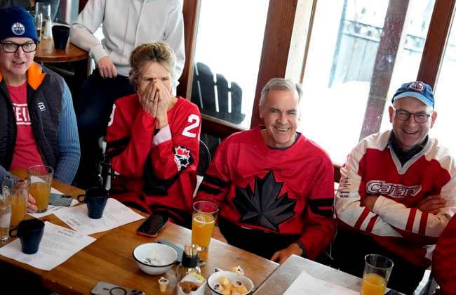 February 22, 2026, Chelsea, Pq, CAN: Prime Minister Mark Carney and his wife Diana Fox Carney join family and friends to watch the gold medal men s ice hockey game between Canada and the United States at the 2026 Milan Cortina Winter Olympics, at a pub in Chelsea, Que., on Sunday, Feb. 22, 2026. Chelsea CAN  - ZUMAc35_ 20260222_zaf_c35_049 Copyright: xJustinxTangx