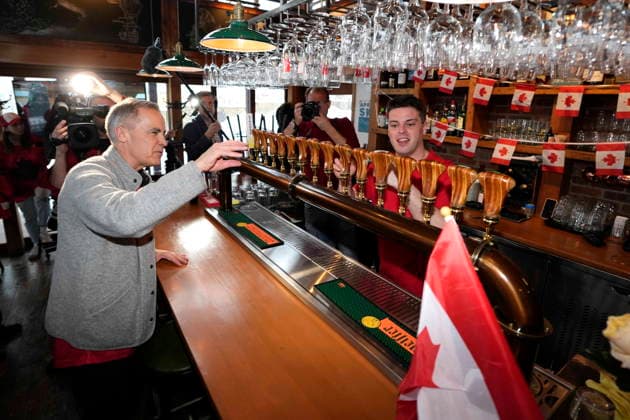 February 22, 2026, Chelsea, Pq, CAN: Prime Minister Mark Carney gets ready to order a drink at the Chelsea Pub, in Chelsea, Que., before the gold medal men s ice hockey game between Canada and the United States at the 2026 Milan Cortina Winter Olympics, on Sunday, Feb. 22, 2026. Chelsea CAN  - ZUMAc35_ 20260222_zaf_c35_052 Copyright: xJustinxTangx