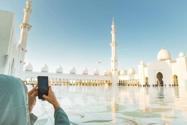 Touristen machen ein Foto von der Landung eines Luxus Privatjets über der ikonischen Großen Moschee von Sheikh Zayed in Abu Dhabi. Moderne Luftfahrt und islamische Architektur heben Opulenz, Reisen und kulturelle Sehenswürdigkeiten hervor Tourist take photo of Luxury private jet landing above the iconic Sheikh Zayed Grand Mosque in Abu Dhabi. Modern aviation and Islamic architecture highlights opulence, travel, and cultural landmarks Copyright: imageBROKER EvaldasxMikoliunas ibxemi16710917.jpg ,model released, Symbolfoto ,property released