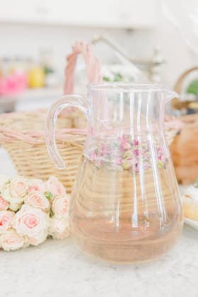 IMAGO Creative, Lifestyle, Feste im Garten #2 Glass pitcher with rose petals and floral arrangement Millville, Massachusetts, United States R_XRKW260219-1969215-01