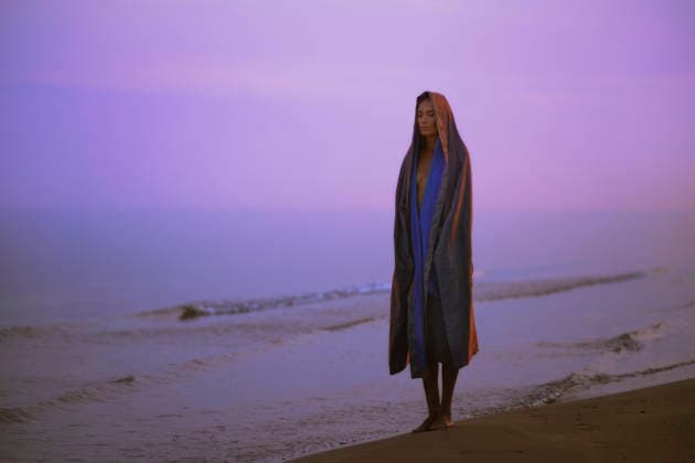 Woman in robe standing on coastline at sunrise in contemplative mood model released, Symbolfoto property released, AZF01134