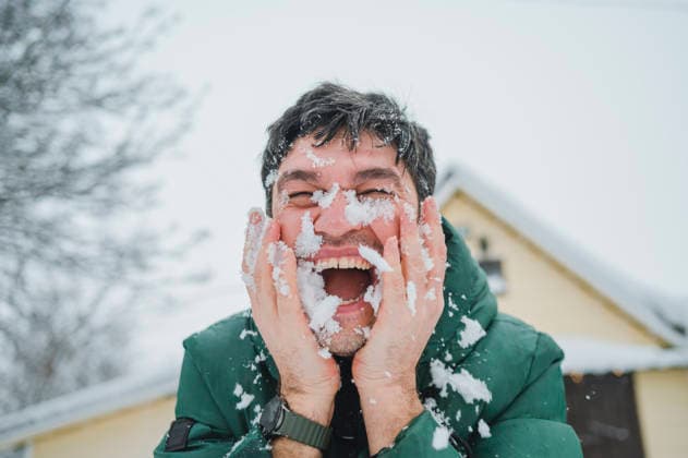 Laughing man with face in snow outside in winter having fun model released, Symbolfoto, ANAF05500