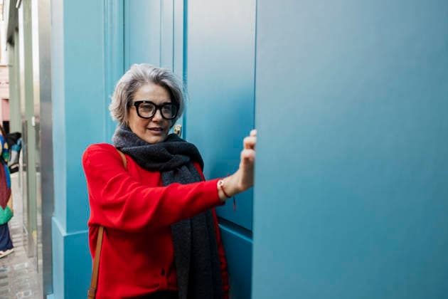 Stylish woman with gray hair rings doorbell outdoors in street style outfit model released, Symbolfoto, ASGF07387