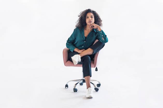 Confident woman in green blouse sitting on chair in bright studio model released, Symbolfoto, JSRF04233
