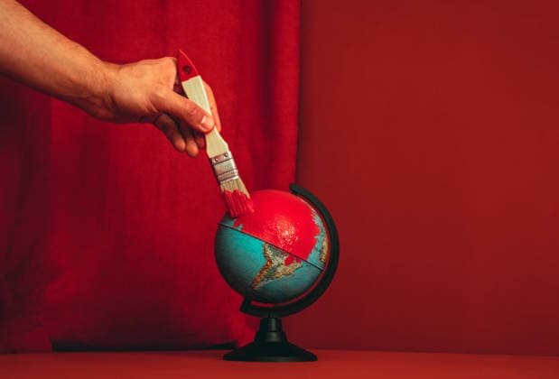 Hand painting globe red with brush symbolizing conflict and change model released, Symbolfoto, AAF00457