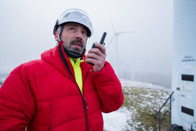 Worker in red jacket communicating via radio at wind energy facility model released, Symbolfoto, ATSF00364