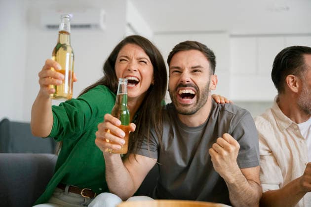 Friends cheering and celebrating football match at home model released, Symbolfoto property released, FLMZF02578