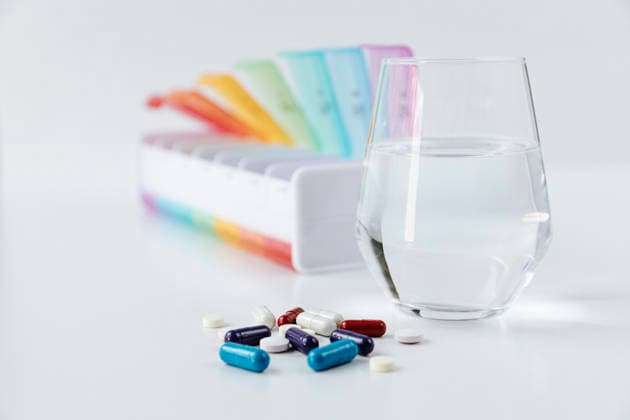 Medication supplements and pill box with water glass for daily routine, HDF00258