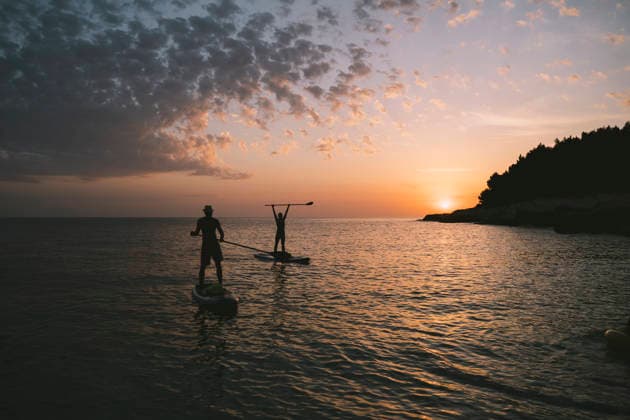 Paddleboarding adventure at sunset with friends by the beach model released, Symbolfoto, NDEF03203
