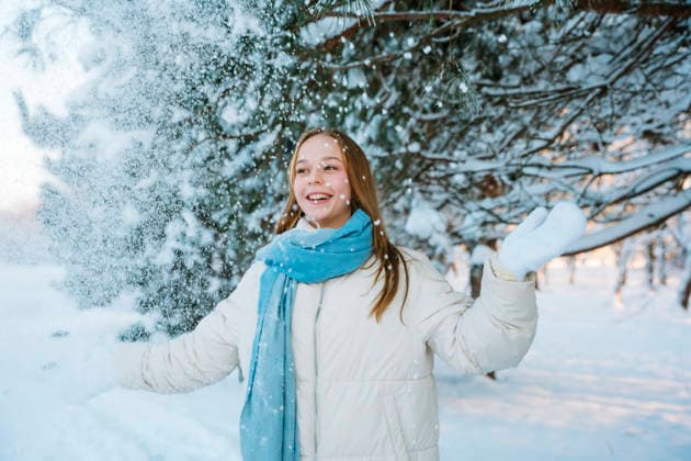 Smiling teen in winter coat and mittens enjoying snow outdoors model released, Symbolfoto, NLAF00746
