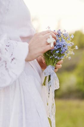 Woman holding blue forget me not bouquet outdoors in summer model released, Symbolfoto, ONAF01144