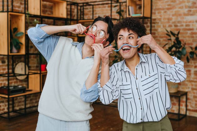 Colleagues having fun making mustaches with pencils in modern office model released, Symbolfoto property released, YTF04542