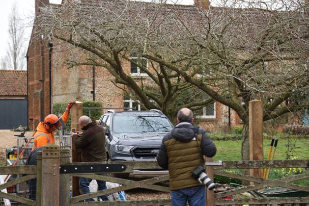 A press photographer watches as workers continues to install fencing around Marsh Farm. Marsh Farm is just along the road from Wood Farm on the Sandringham Estate where Andrew Mountbatten-Windsor is staying. Mountbatten-Windsor was arrested last week, and taken to Aylsham police station before being released under investigation, and returning to Wood Farm. Andrew Mountbatten-Windsor, formerly Prince Andrew The Duke of York, has previously denied any wrongdoing in relation to sex offender Jeffrey Epstein. Andrew Mountbatten-Windsor, Sandringham, Norfolk, on 25th February, 2026 