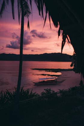 Stunning pink sunset over tropical island in the Philippines Captivating sunset view in the Philippines with vibrant pink skies over a tranquil beach and silhouette of a traditional boat, capturing the essence of Southeast Asian travel. Model Released LidiaMoya_ID33817_1191048_008 Copyright: xLidiaxMoyax RECORD DATE NOT STATED