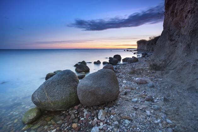 Steinstrand mit großen Findlingen an der Steilküste am Greifswalder Bodden in der Abenddämmerung nach Sonnenuntergang, Naturschutzgebiet Mönchgut, Groß Zicker, Halbinsel Mönchgut, Insel Rügen, Mecklenburg-Vorpommern, Deutschland Rocky beach with large boulders on the cliffs on the Bay of Greifswald at dusk after sunset, Mönchgut nature reserve, Groß Zicker, Mönchgut peninsula, Rügen island, Mecklenburg-Western Pomerania, Germany Copyright: imageBROKER AndreasxVitting iblavg16809699.jpg