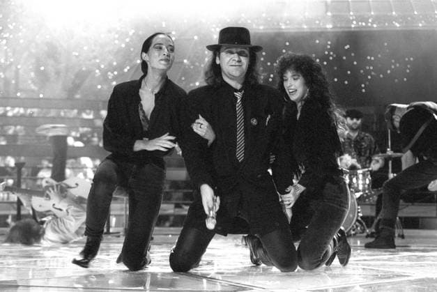 Udo Lindenberg (Sänger) 09 90 hör Udo Lindenberg mit Band während eines Auftritts bei Ein Kessel Buntes (DFF) im September 1990 TV Fernsehen Fernsehshow Show DDR Deutschland deutsch deutscher Mann Gesang Musik Musiker Künstler Rockmusiker Rock Pop Popmusiker Maler Rocksänger Popsänger Auftritt german singer musician painter quer kniend Mikrofon haltend lächelnd Bühne Deko Dekoration Bandmitglieder im Arm Backgroundsängerinnen sw *** Udo Lindenberg singer 09 90 listen Udo Lindenberg with band during a performance at Ein Kessel Buntes DFF in September 1990 TV television show show DDR Germany german german man singing music musician artist rock musician rock pop pop musician painter rock singer pop singer performance german