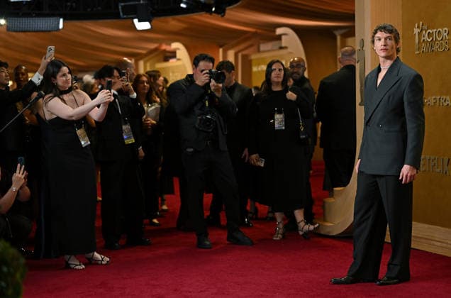 Photographers scramble to get photos of Connor Storrie (R) as he arrives on the red carpet for the 32nd Annual Actor Awards presented by SAG-AFTRA at the Shrine Auditorium and Expo Hall in Los Angeles, California on Sunday, March 1, 2026.  LAP202603011706 CHRISxCHEW