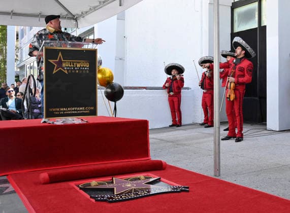 Comedian Gabriel Fluffy Iglesias speaks with a mariachi band member during an unveiling ceremony honoring him with the 2,838th star on the Hollywood Walk of Fame in Los Angeles on Tuesday, March 3, 2026.  LAP2026030311 JIMxRUYMEN