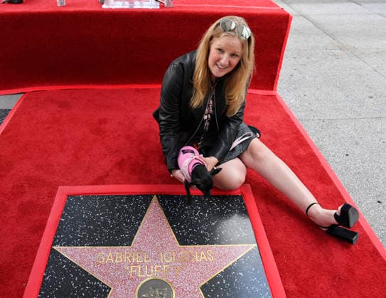 Comedian Gabriel Fluffy Iglesias partner Tiffany Kate sits beside his star with their dog during unveiling ceremony honoring him with the 2,838th star on the Hollywood Walk of Fame in Los Angeles on Tuesday, March 3, 2026.  LAP2026030326 JIMxRUYMEN