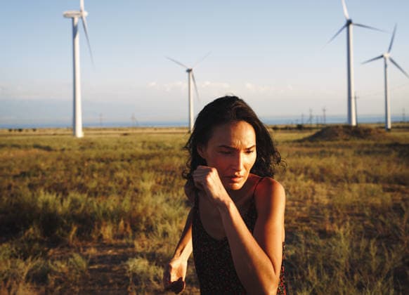 Woman running in the field with wind turbines California City, California, United States CR_ARZH250523-1737191-01 ,model released, Symbolfoto