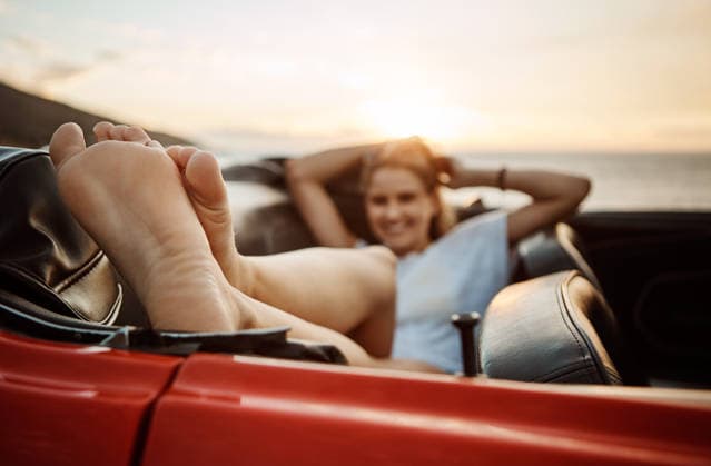 Road trip, rest or feet in car with beach sunset, outdoor destination or relaxing on tourist vacation. Travel, chill or woman at ocean with vehicle, weekend break or summer evening in Australia model released property released Copyright: xx