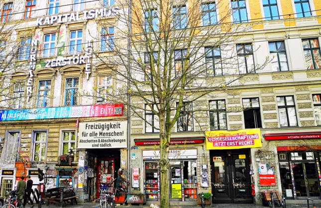 Fassade der Kastanienallee 86 mitten im Szenekiez Prenzlauer Berg. Seit der Wende 1989 schmueckt der Kapiatalismus-Schriftzug die Fassaden-Front des alternativen Hauses. Daneben der Buchladen Zur schwankenden Weltkugel (Bildmitte unten) im Haus, Kastanienallee 85. Der Buchladen gehoert zu den drei Favoriten fuer die Auszeichnung am 19. Maerz des Deutschen Buchhandels. Jetzt nach Recherche des Kulturstaatsminister Wolfram Weimer im Visier des Verfassungschutzes stehen diese drei nicht mehr auf der Liste der Nominierten.