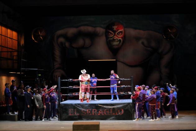 Misha Kiria (links als Taddeo), El Comandante Rambo (Wrestler) und Pascal Spalter (Wrestler), mittig v.l., sowie Ensemble während der Fotoprobe für L Italiana in Algeri in der Deutschen Oper in Berlin, 5. März 2026. Dramma giocoso per musica in zwei Akten von Gioacchino Rossini. Musikalische Leitung Alessandro De Marchi. Inszenierung Rolando Villazon. Bühne Harald Thor. Kostüme Brigitte Reiffenstuel. Premiere ist am 8. März 2026. Deutsche Oper Berlin L Italiana in Algeri