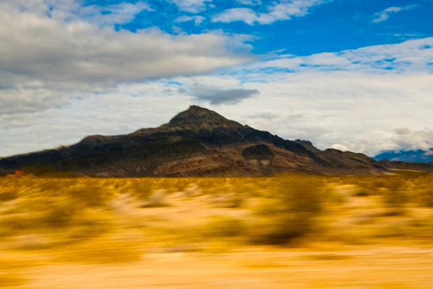 View across a desert landscape to a sharp peak, seen from a moving vehicle. Landscape,United States,View across a desert landscape to a sharp peak, seen from a moving vehicle.  View across a desert landscape to a sharp peak, seen from a moving vehicle. RECORD DATE NOT STATED