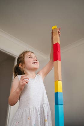 Child girl stacking wooden toy blocks, early skill development Corby, England, United Kingdom CR_ATMT260306-1978630-01 ,model released, Symbolfoto