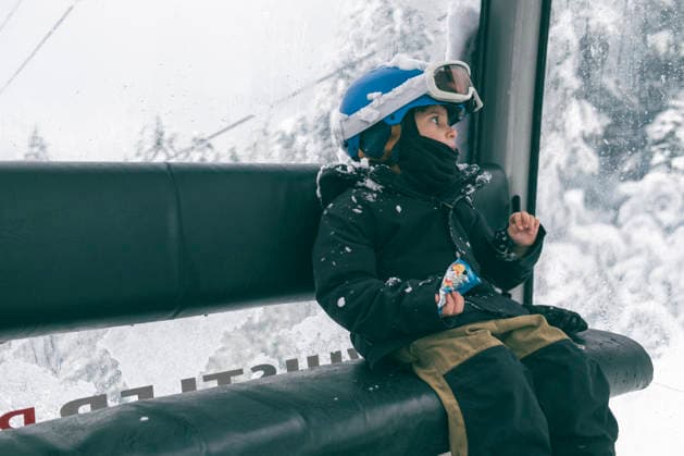 You boy snowboarder rides gondola and has a snack on winter day Canada, British Columbia, Whistler CR_PSFZ260305C-1958592-01 ,model released, Symbolfoto